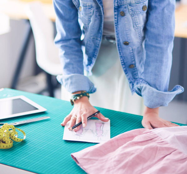 Fashion designer woman working on her designs in the studio