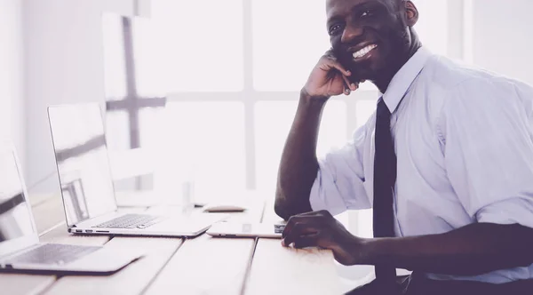 Afrikansk amerikansk affärsman på headset arbetar på sin bärbara dator — Stockfoto