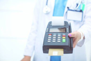 Doktor ödeme terminalini elinde tutuyor. Sağlık hizmetlerinin parasını ödüyorum. Doktor.