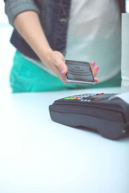 Müşteri ile smartphone Nfc teknolojisi kullanılarak dükkanda ödüyor. NFC teknolojisi. Müşteri ödeme