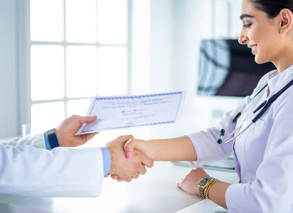 El médico da la mano a un paciente aislado sobre fondo blanco — Foto de Stock