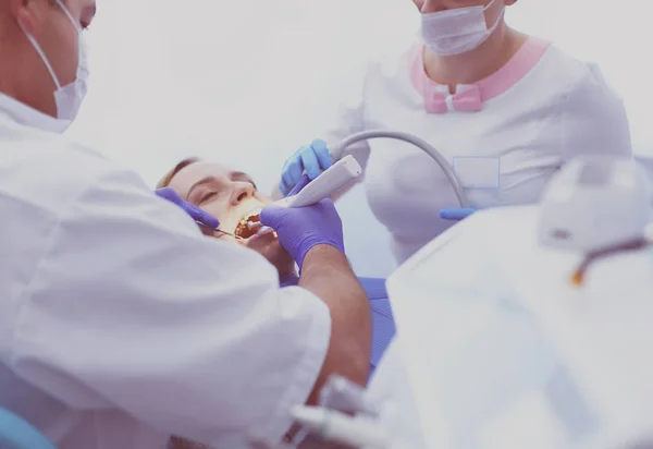 Obraz młodej damy z dentystą nad nią przed sprawdzeniem jamy ustnej — Zdjęcie stockowe