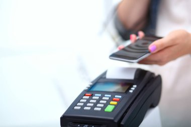 Müşteri ile smartphone Nfc teknolojisi kullanılarak dükkanda ödüyor. NFC teknolojisi. Müşteri ödeme