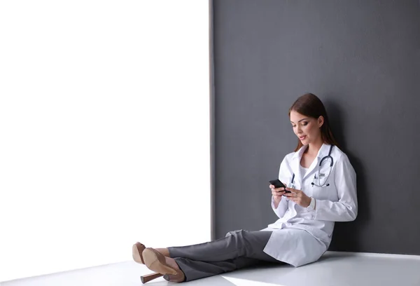 Naislääkäri, joka käyttää tabletin tietokonetta sairaalan aulassa — kuvapankkivalokuva