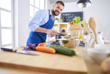 Adam ev mutfağında lezzetli ve sağlıklı yemekler hazırlıyor.