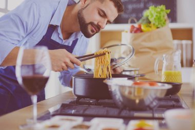 Adam ev mutfağında lezzetli ve sağlıklı yemekler hazırlıyor.