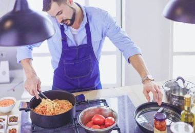 Adam ev mutfağında lezzetli ve sağlıklı yemekler hazırlıyor.