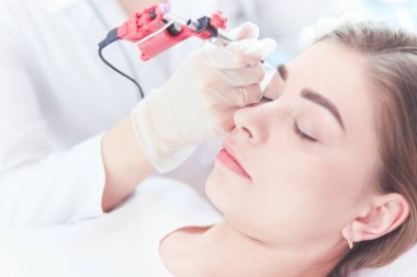 Kırmızı dudaklı genç bir kız kalıcı makyaj, mikro pigmentasyon