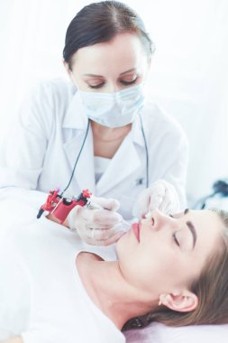 Kırmızı dudaklı genç bir kız kalıcı makyaj, mikro pigmentasyon