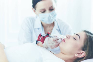 Kırmızı dudaklı genç bir kız kalıcı makyaj, mikro pigmentasyon