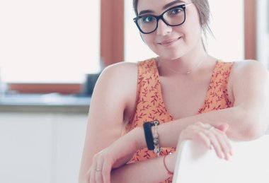 Mutfakta masada oturan genç bir kadın.