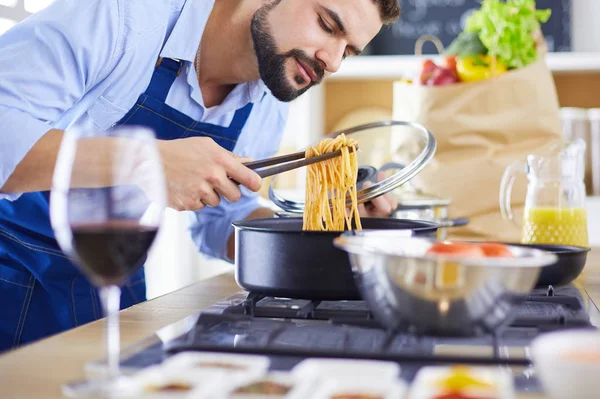 家のキッチンでおいしいと健康食品を準備する男 — ストック写真
