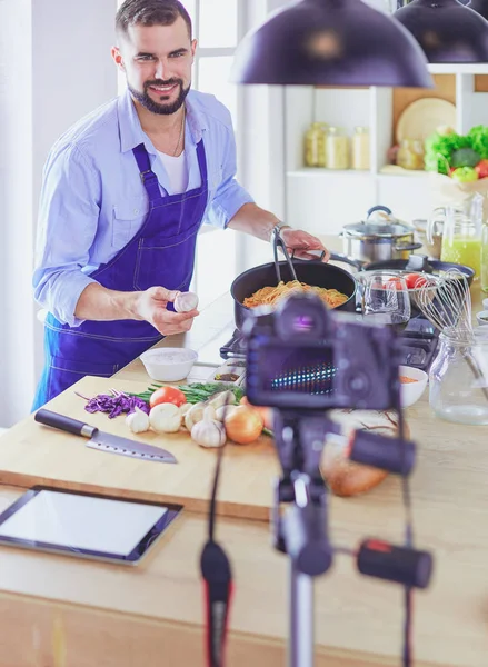 Man holding paper bag full of groceries on the kitchen background. Shopping and healthy food concept — Stock Photo, Image