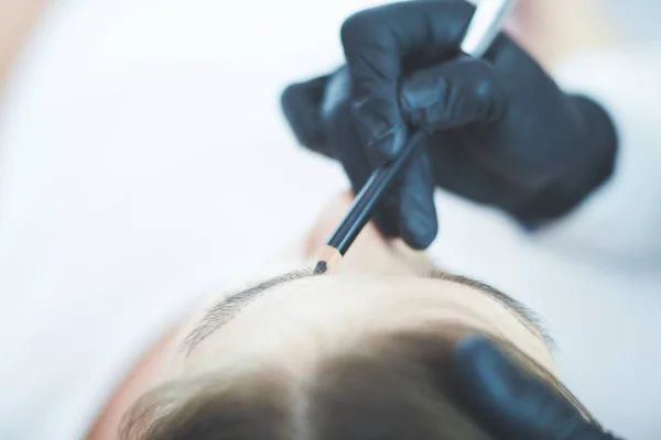 Cosmetologist applying permanent make up on eyebrows — Stock Photo, Image