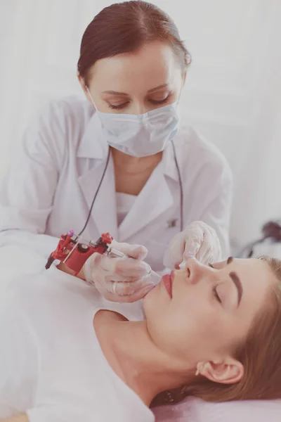 A young girl having red lips permanent makeup, micropigmentation — Stock Photo, Image