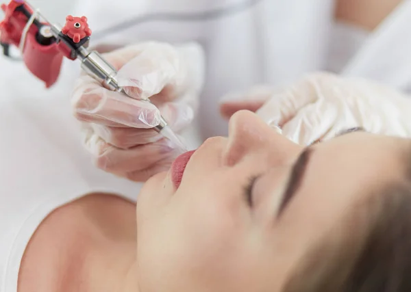 A young girl having red lips permanent makeup, micropigmentation — Stock Photo, Image