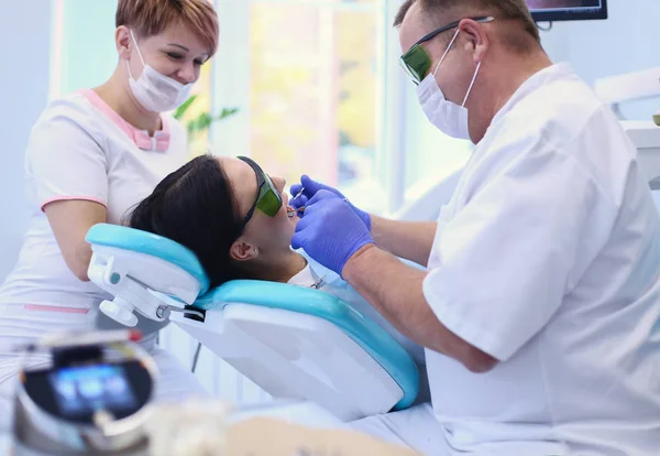 Homem dentista trabalhando em seus pacientes dentes — Fotografia de Stock