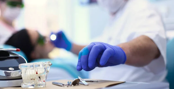 Senior male dentist adjust searchlight before starting work