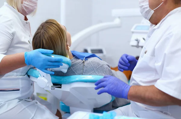 Médico dentista sênior em consultório odontológico conversando com paciente do sexo feminino e se preparando para o tratamento — Fotografia de Stock