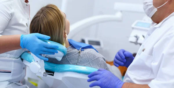 Médico dentista sênior em consultório odontológico conversando com paciente do sexo feminino e se preparando para o tratamento — Fotografia de Stock