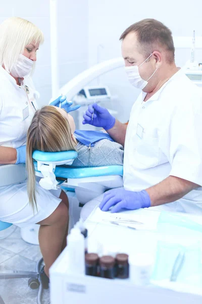 Tandarts en zijn assistent voeren een grondig onderzoek uit — Stockfoto