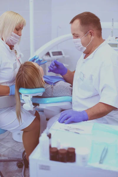 El dentista y su asistente realizan un examen minucioso —  Fotos de Stock