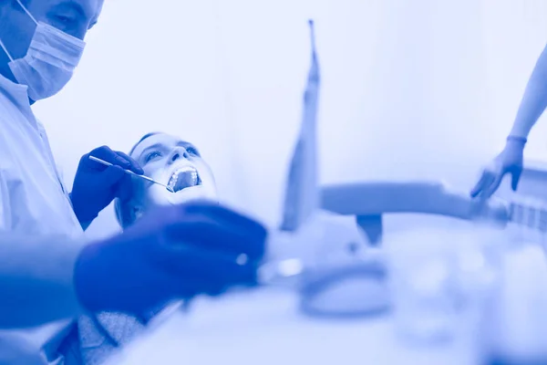 Detail van de hand houden tandheelkundige hulpmiddelen in tandheelkundige kliniek. Tandartsconcept — Stockfoto