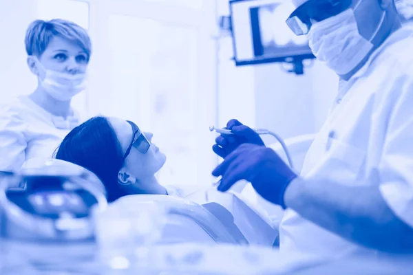 Beautiful senior woman at dentist having dental treatment at dentists office