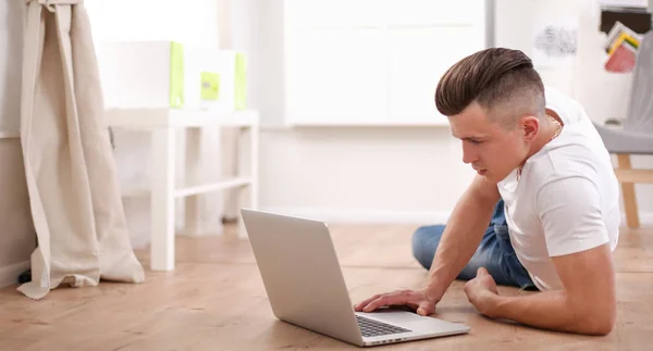 Knappe zelfverzekerde man die thuis in een fauteuil zit — Stockfoto