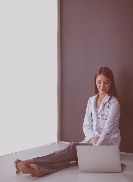 Female doctor using tablet computer in hospital lobby