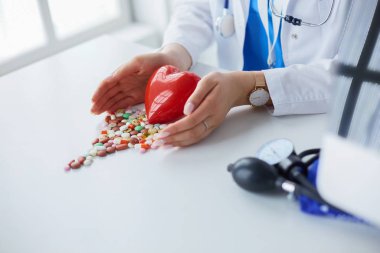 Masada kırmızı kalbi ve steteskopu olan kardiyolog.