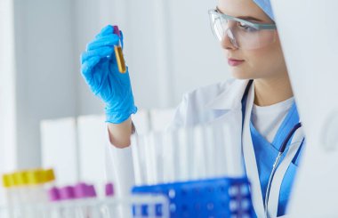 Laboratuvar asistanı bir kan örneğini analiz ediyor.