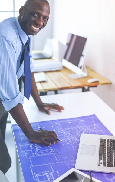 Arquitecto afroamericano trabajando con computadoras y planos en la oficina —  Fotos de Stock