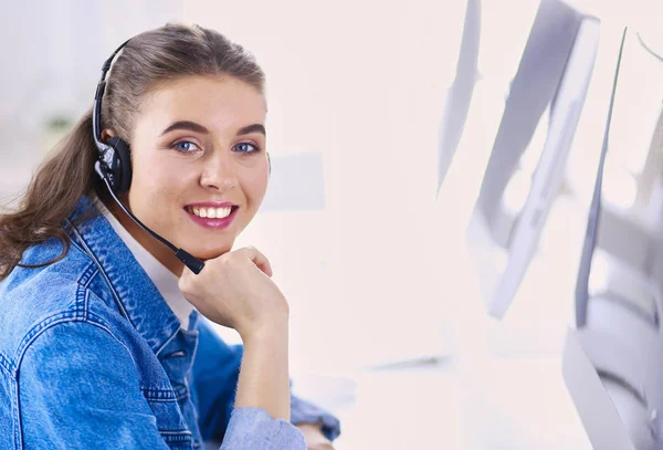 Retrato de mulher de negócios bonita trabalhando em sua mesa com fone de ouvido e laptop — Fotografia de Stock