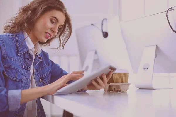 Jovem mulher usando tablet digital no escritório — Fotografia de Stock