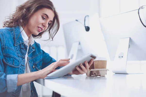 Jovem mulher usando tablet digital no escritório — Fotografia de Stock