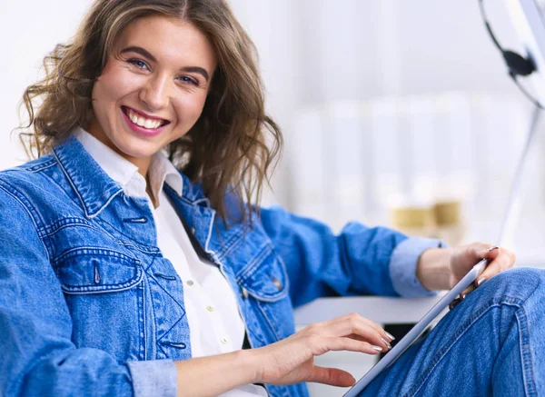 Mujer sonriente bebiendo café y usando la tableta en el café — Foto de Stock