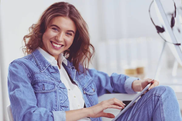 Mujer sonriente bebiendo café y usando la tableta en el café — Foto de Stock