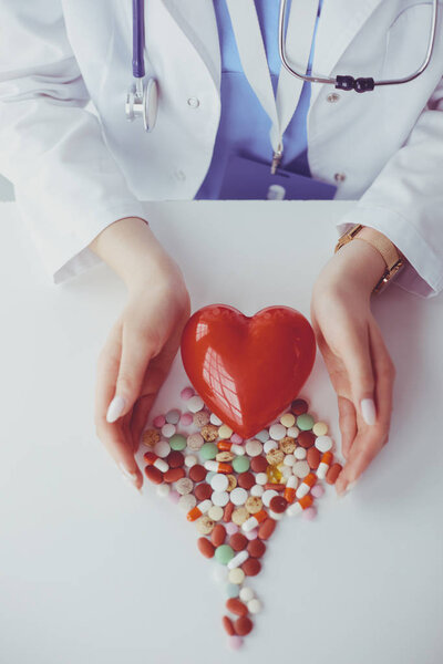 Кардиолог с красным сердцем и стетоскопом за столом