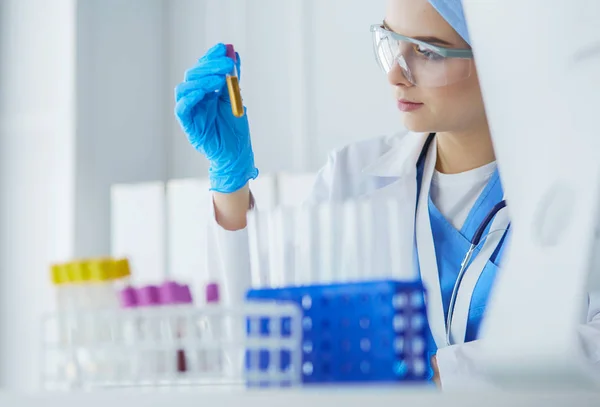 Asistente de laboratorio mujer analizando una muestra de sangre — Foto de Stock