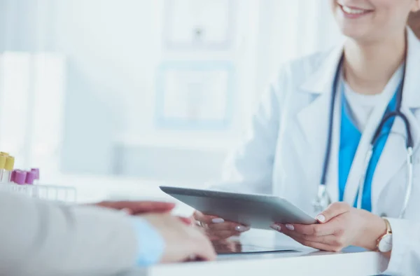 Female doctor using tablet computer in hospital lobby, smiling — Stock Photo, Image