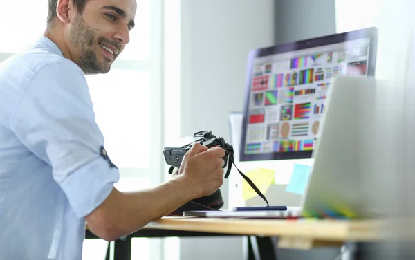 Retrato de jovem designer sentado no estúdio gráfico na frente de laptop e computador enquanto trabalhava online. — Fotografia de Stock