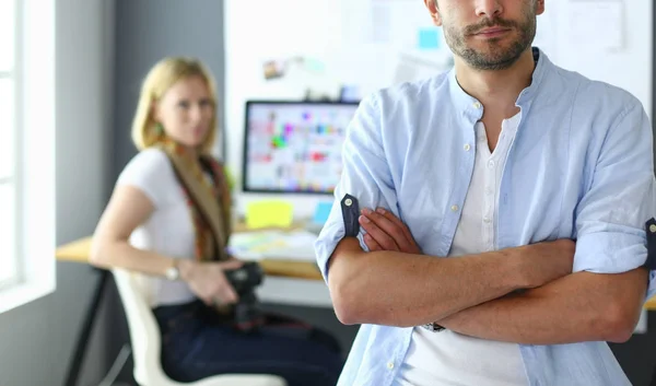 Portrait of young designer in front of laptop and computer while working. Assistant using her mobile at background. — Stock Photo, Image