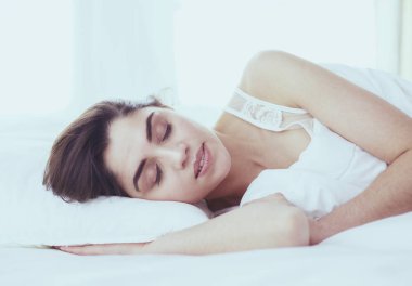 Güzel bir kadın yatağında uzanıyor.