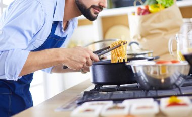 Adam ev mutfağında lezzetli ve sağlıklı yemekler hazırlıyor.