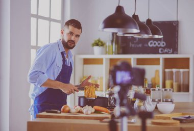 Mutfak arka planında poşet dolusu erzak tutan adam. Alışveriş ve sağlıklı gıda konsepti