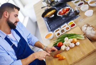 Adam ev mutfağında lezzetli ve sağlıklı yemekler hazırlıyor.