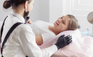 Güzellik salonunda kaş makyajı yapılan genç bir kadın.