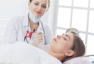 Kırmızı dudaklı genç bir kız kalıcı makyaj, mikro pigmentasyon