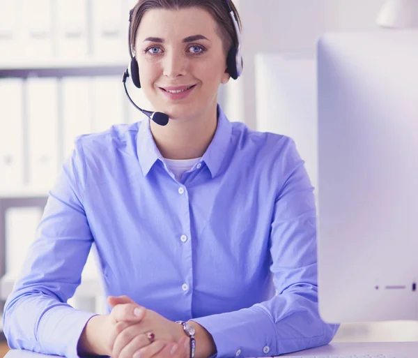 Mujer bastante joven y seria que trabaja como operador de telefonía de apoyo con auriculares en la oficina —  Fotos de Stock